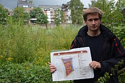 Bezirksabgeordneter Martin Bill vor dem verwahrlosten Grundstück Meenkwiese. In der Hand den Bebauungsplan, der bis zu 80 Wohnungen dort ermöglicht. (Reiffert/GAL-Fraktion HH-Nord)