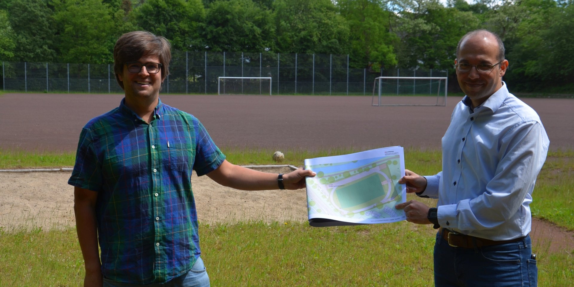 Timo B. Kranz (GRÜNE, links) und Nizar Müller (Oberalster VfW) mit einem ersten Entwurf für den neuen Sportplatz (Reiffert/GRÜNE Fraktion Hamburg-Nord)