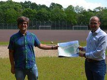 Timo B. Kranz (GRÜNE, links) und Nizar Müller (Oberalster VfW) mit einem ersten Entwurf für den neuen Sportplatz (Reiffert/GRÜNE Fraktion Hamburg-Nord)