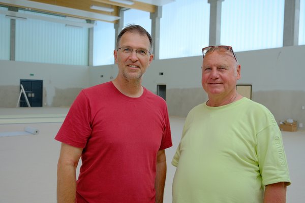 Oliver Camp (GRÜNE, l.) und Rüdiger Wendt (SPD, r.) in der neuen Sporthalle der Adolph-Schönfelder-Schule direkt an der Dehnhaide