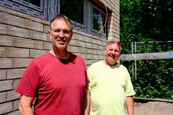 Oliver Camp (GRÜNE, l.) und Rüdiger Wendt (SPD, r.) neben der neuen Sporthalle der Adolph-Schönfelder-Schule direkt an der Dehnhaide