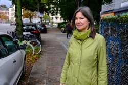 Simone Dietz an einer der vielen schmalen Gehwegstellen. Hier müssen sich Fußgänger*innen heute noch zwischen parkenden Autos und Müllcontainerboxen hindurchzwängen