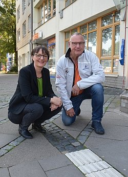 Daniela Dalhoff (GRÜNE, links) und Rüdiger Wendt (SPD) vor dem Louis-Braille-haus. Die im Boden eingelassenen taktilen Elemente enden kurz vor der Tür