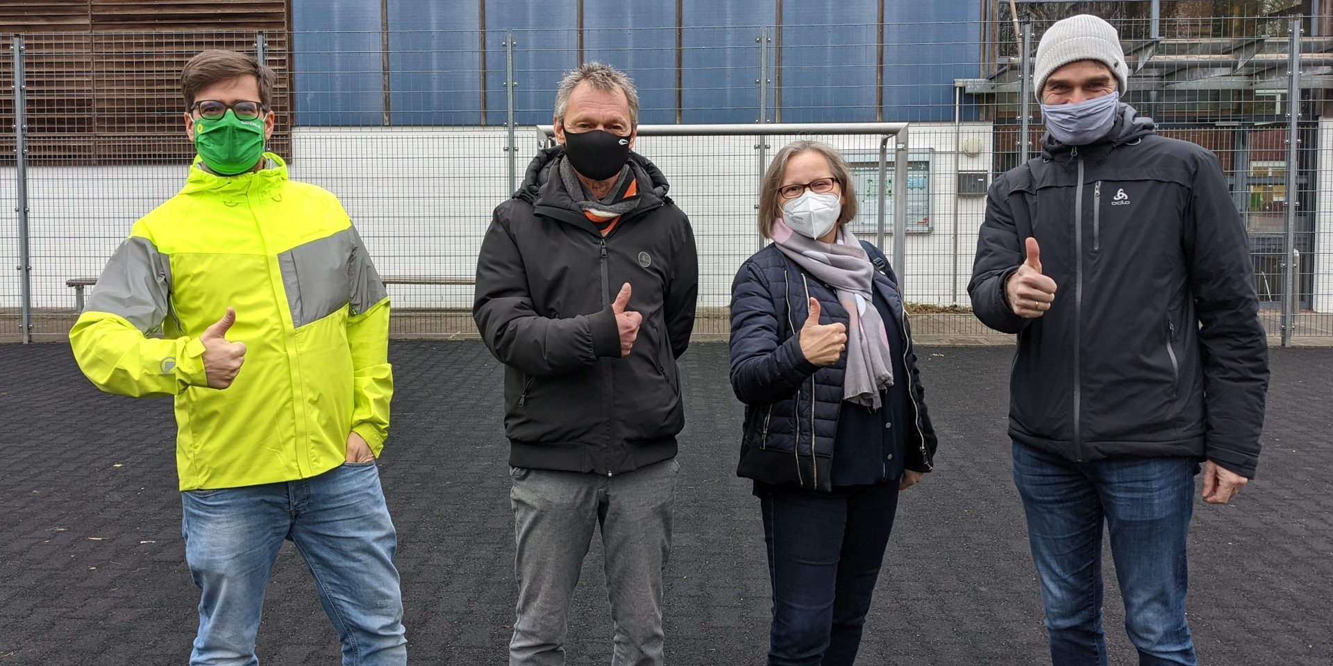 vlnr: Timo B. Kranz (GRÜNE), Michael Stuhr (Stellv. Vorsitzender SiB-Club), Maren Schindeler-Grove (1. Vorsitzende SiB-Club), Carsten Heinrich (Stellv. Schulleiter der Stadtteilschule Am Heidberg) auf der Fläche, die überdacht werden soll. Auf dem Schulgelände herrscht strenge Maskenpflicht