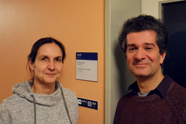 Tanja Schmedt auf der Günne und Dr. Anil Kaputanoglu vor einem der neuen interaktiven Türschilder (oben)