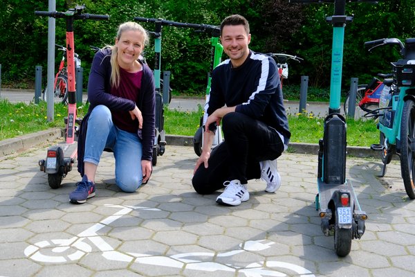 Katharina Fischer-Zernin (GRÜNE, links) und Momme Dähne (SPD) an einer Abstellfläche für eScooter bei der U-Bahnstation Langenhorn Nord