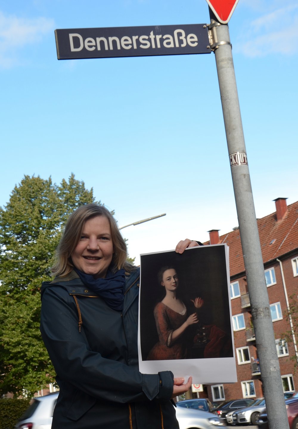 Simone Dornia an der Dennerstraße mit einem Gemälde von Catharina Denner, das ihr Vater Balthasar malte. Allein nach ihm ist die Straße bisher benannt