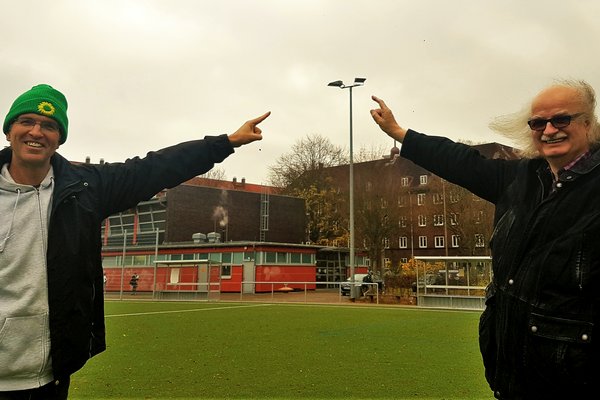 Oliver Camp (l., GRÜNE) und Ulrich Bunsmann (DSC Hanseat) auf dem Sportplatz