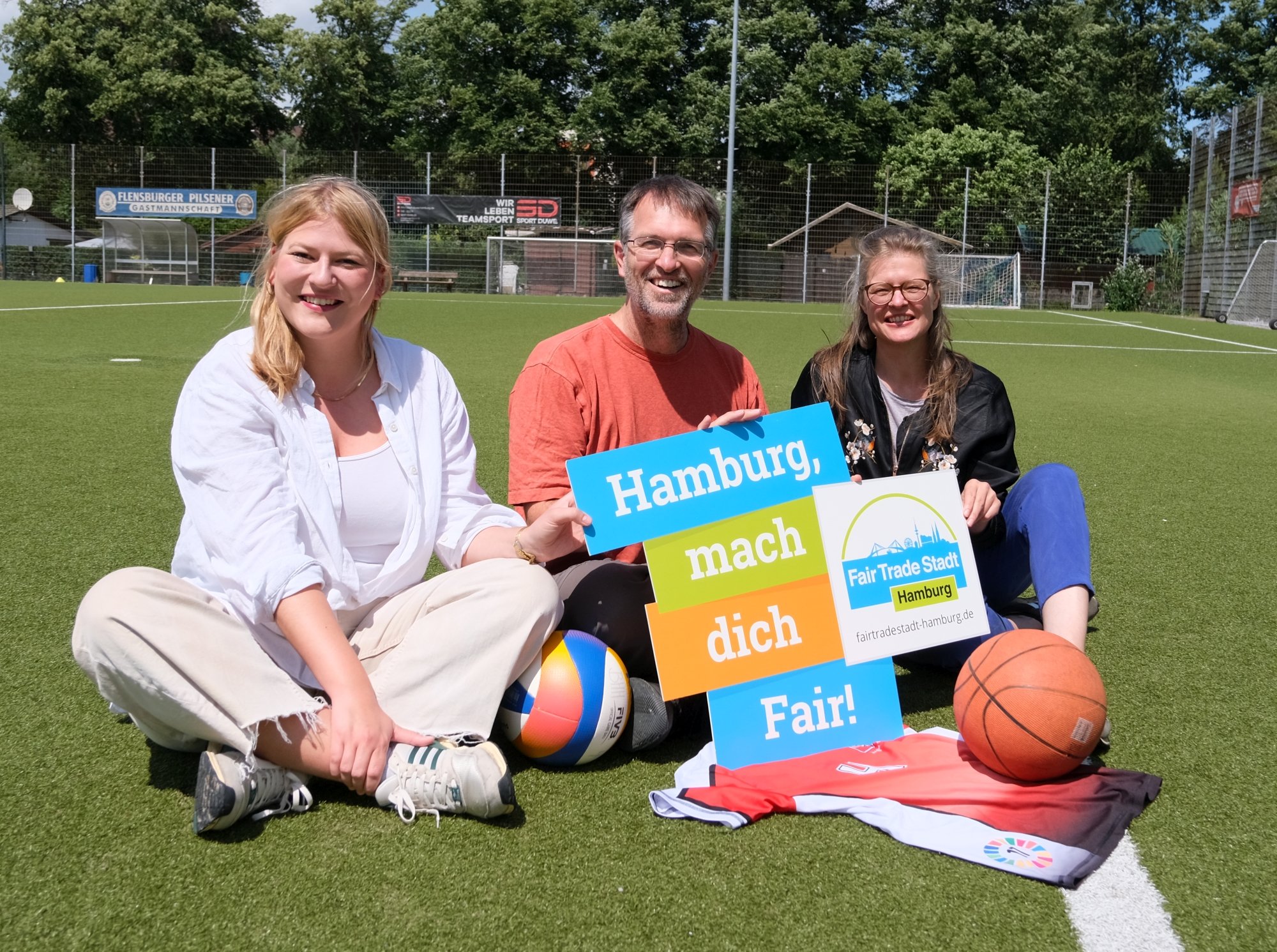 Lena Otto (SPD), Oliver Camp (GRÜNE) und Christine Prießner (Fair Trade Stadt Hamburg) mit einem fairen Trikot (Reiffert/GRÜNE Fraktion Nord)