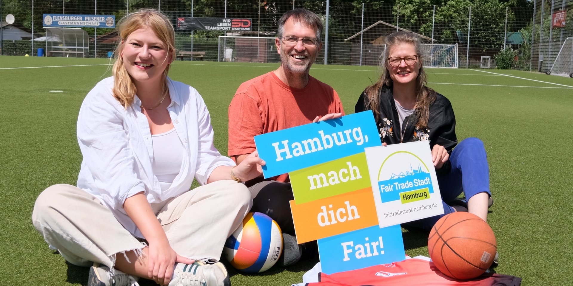 Lena Otto (SPD), Oliver Camp (GRÜNE) und Christine Prießner (Fair Trade Stadt Hamburg) mit einem fairen Trikot (Reiffert/GRÜNE Fraktion Nord)