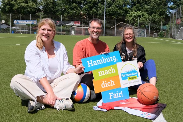 Lena Otto (SPD), Oliver Camp (GRÜNE) und Christine Prießner (Fair Trade Stadt Hamburg) mit einem fairen Trikot (Reiffert/GRÜNE Fraktion Nord)